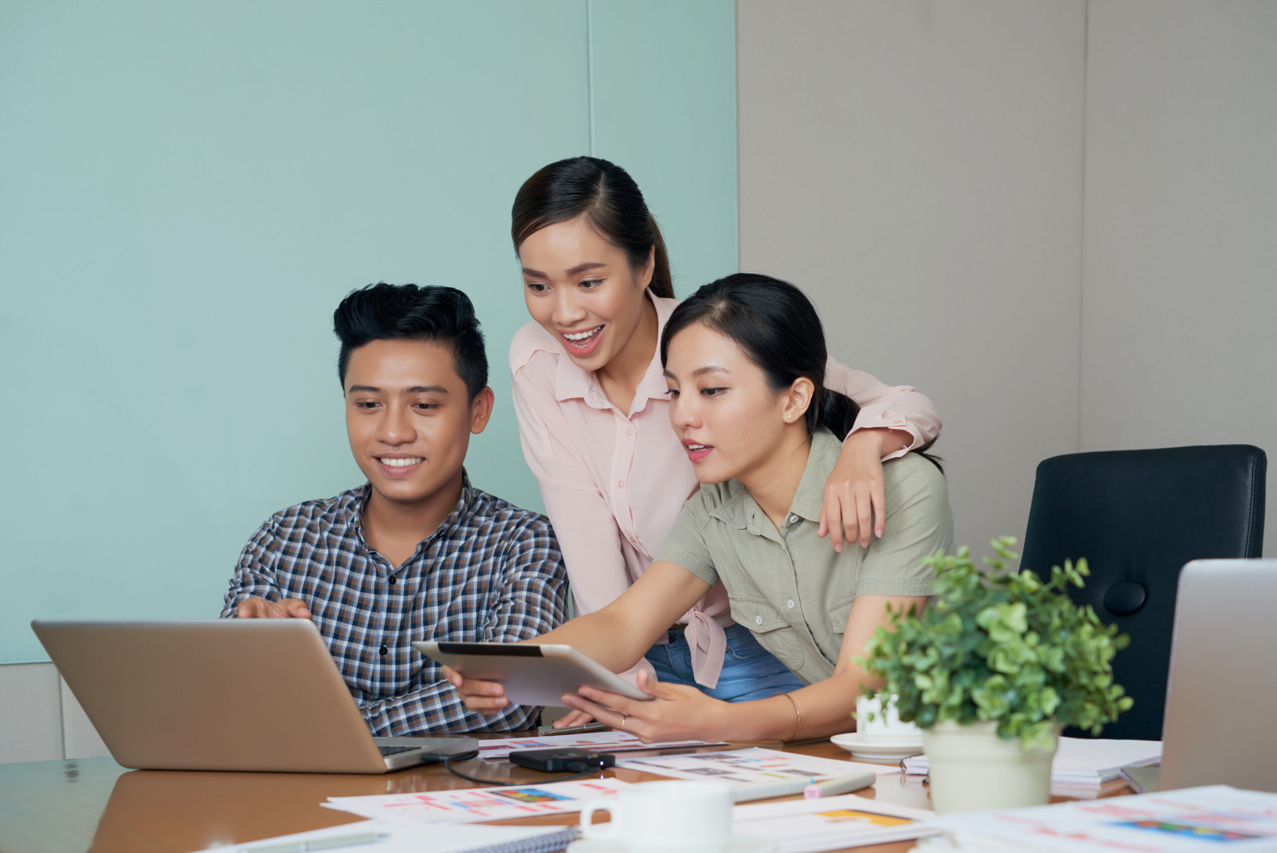 Excited young business people reading news on laptop screen