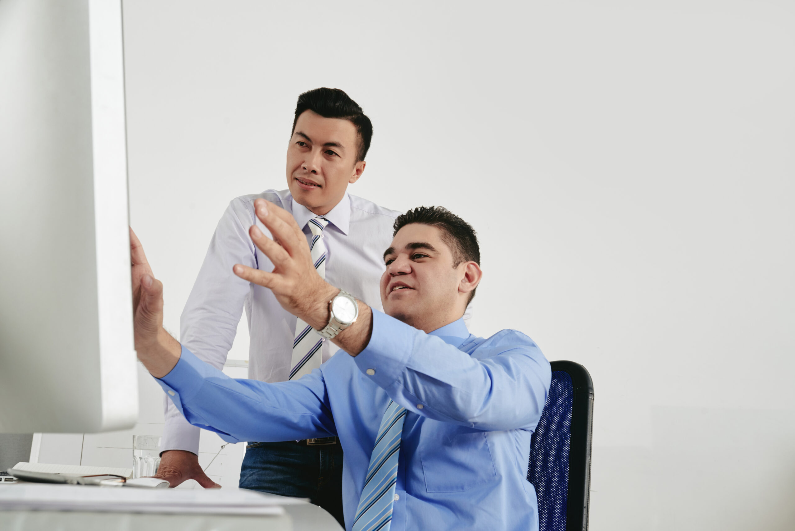 Businessman showing his idea on computer screen to his coworker